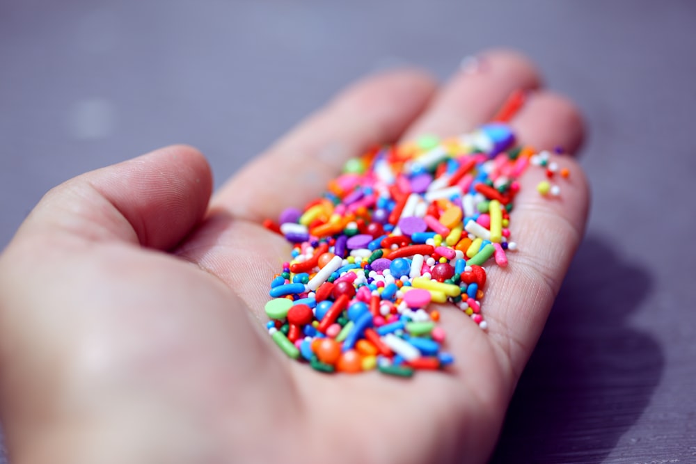 personne tenant un bracelet de perles multicolores