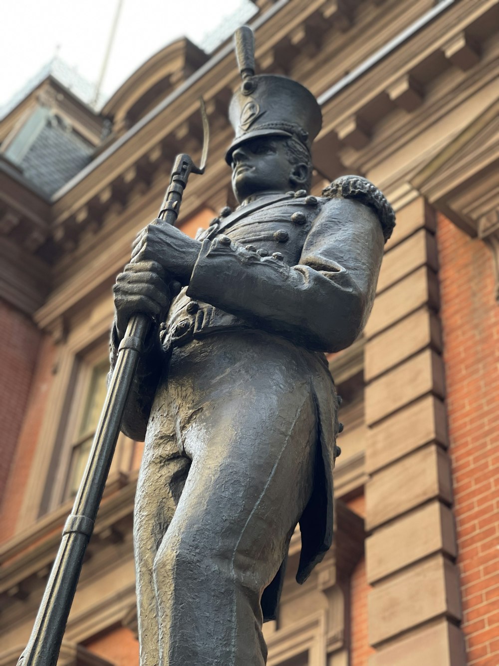man holding rifle statue during daytime