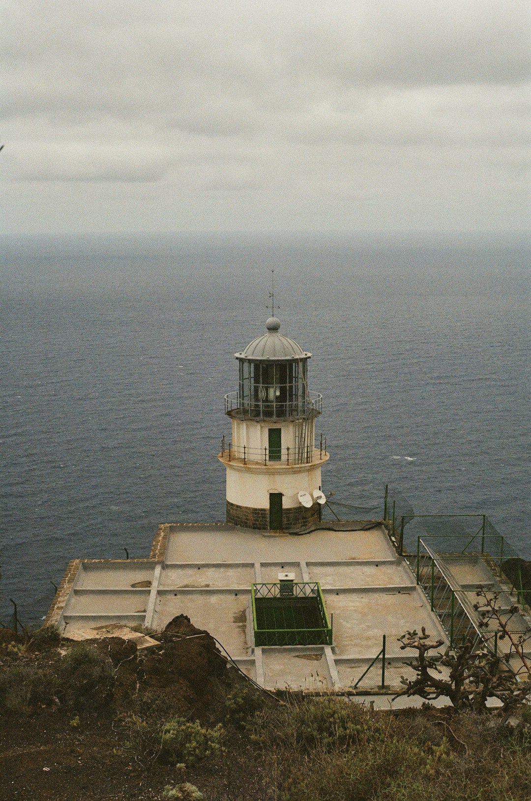 white and black lighthouse near body of water during daytime
