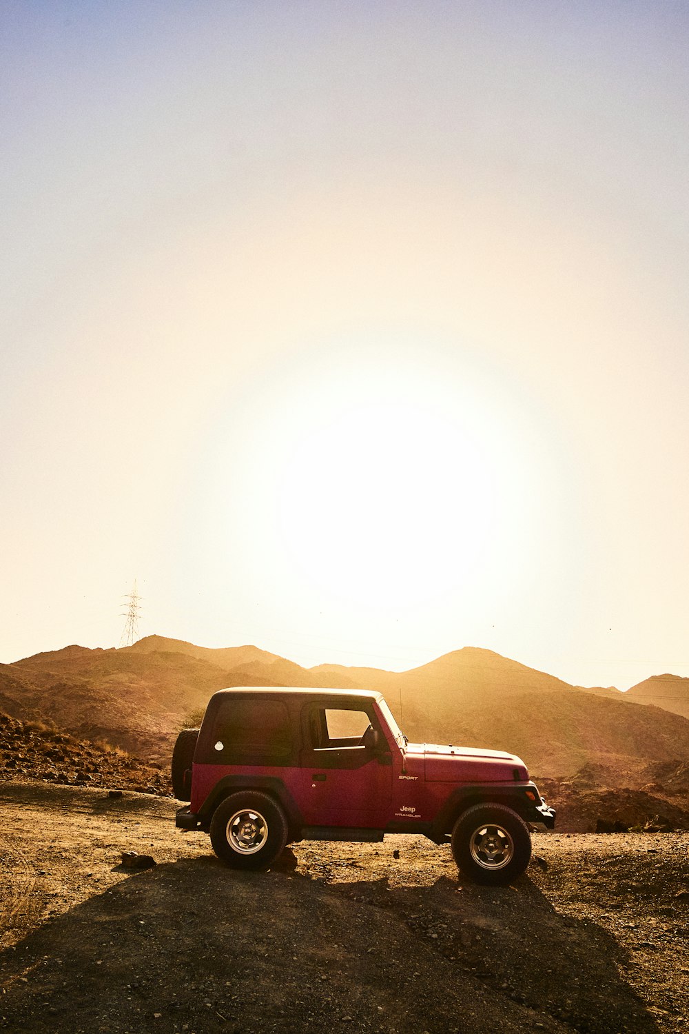 red suv on brown dirt road during daytime