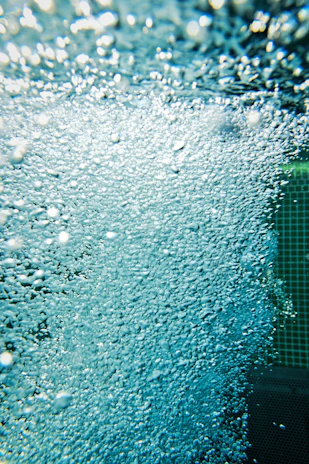 Close-up of sparkling water bubbles rising in a modern swimming pool.