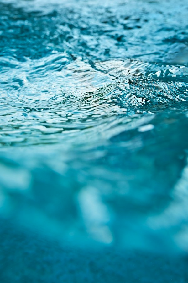 Close-up texture of rippling clear blue pool water
