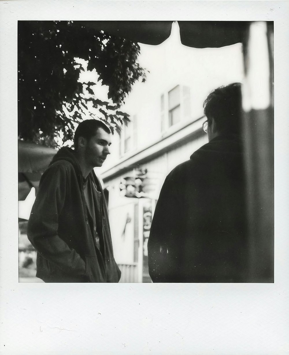 man in black coat standing beside man in black coat