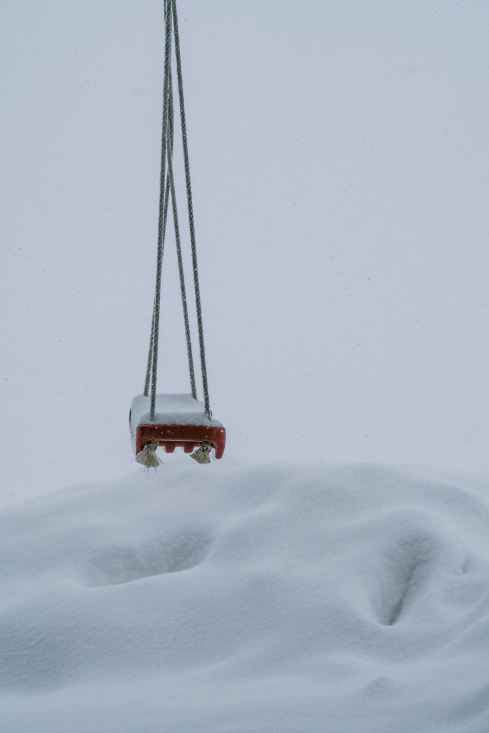 red and black swing on snow covered ground