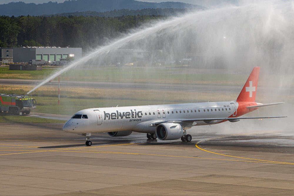 white and red passenger plane on airport during daytime