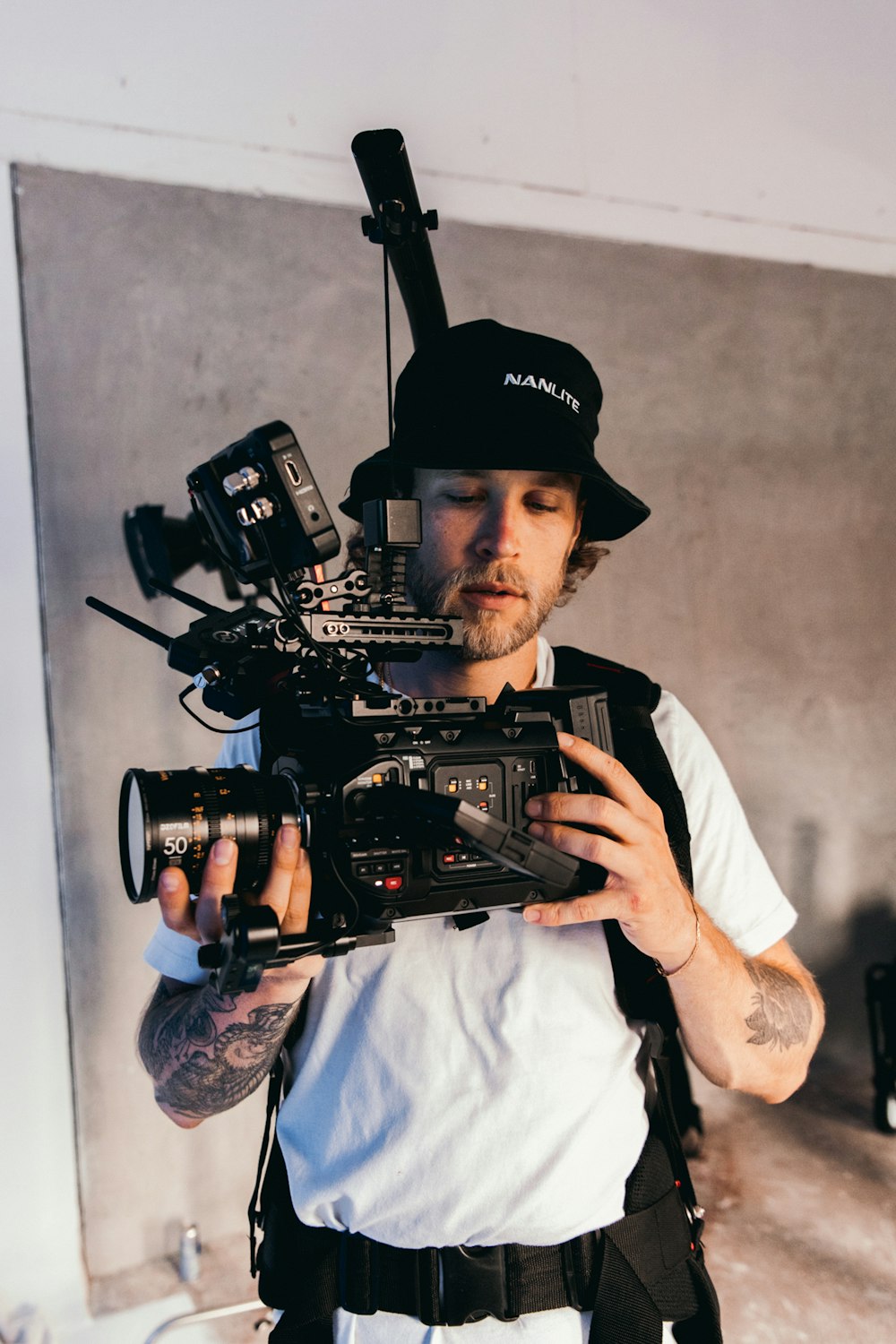 man in white dress shirt holding black video camera