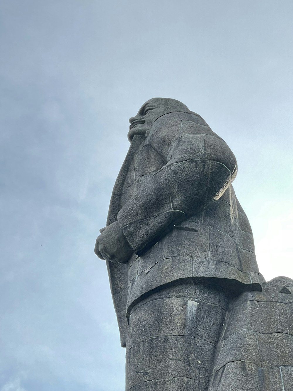 statua di cemento grigio sotto il cielo bianco durante il giorno