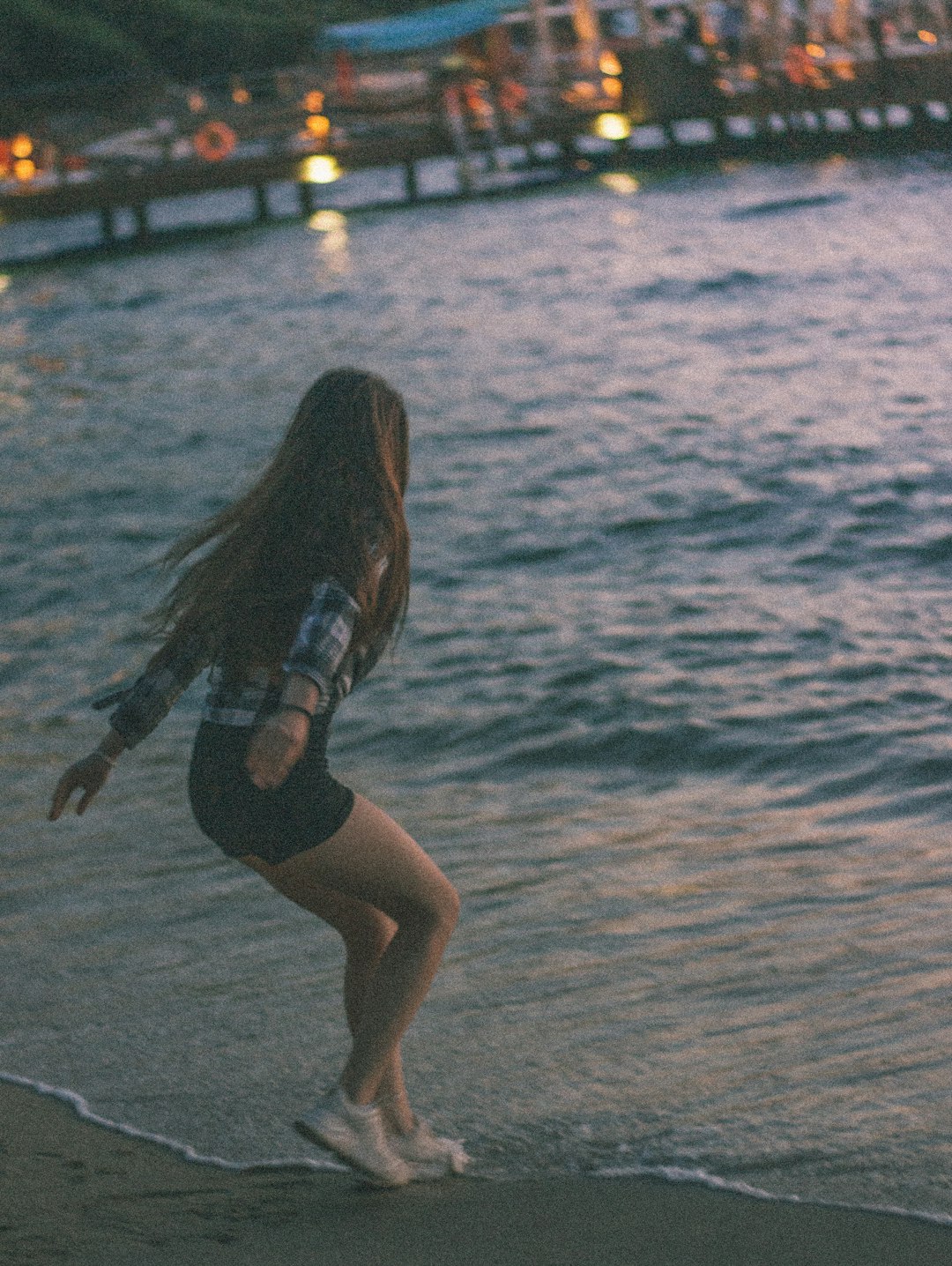 woman in black shorts running on beach during daytime