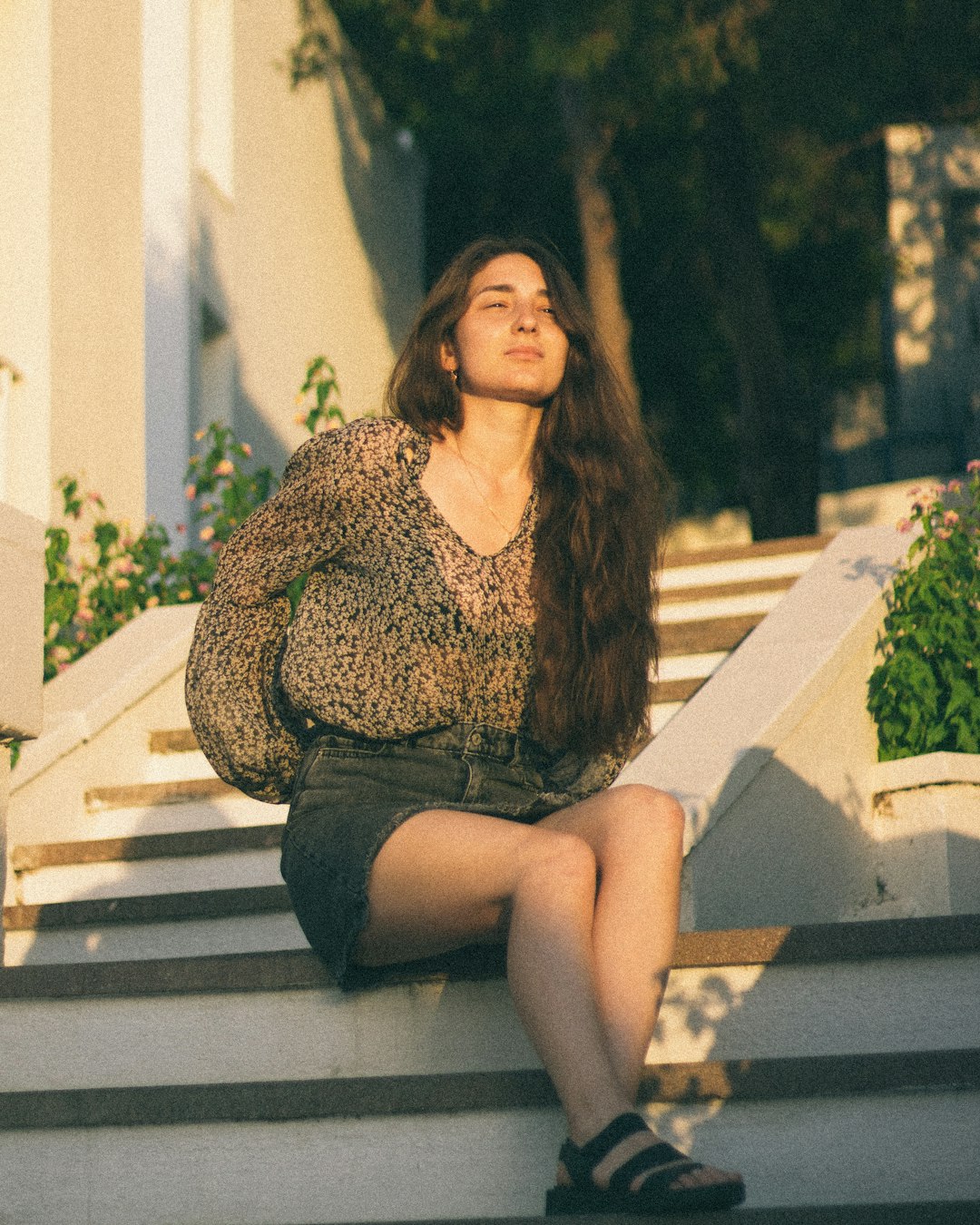 woman in brown long sleeve shirt sitting on white concrete bench during daytime