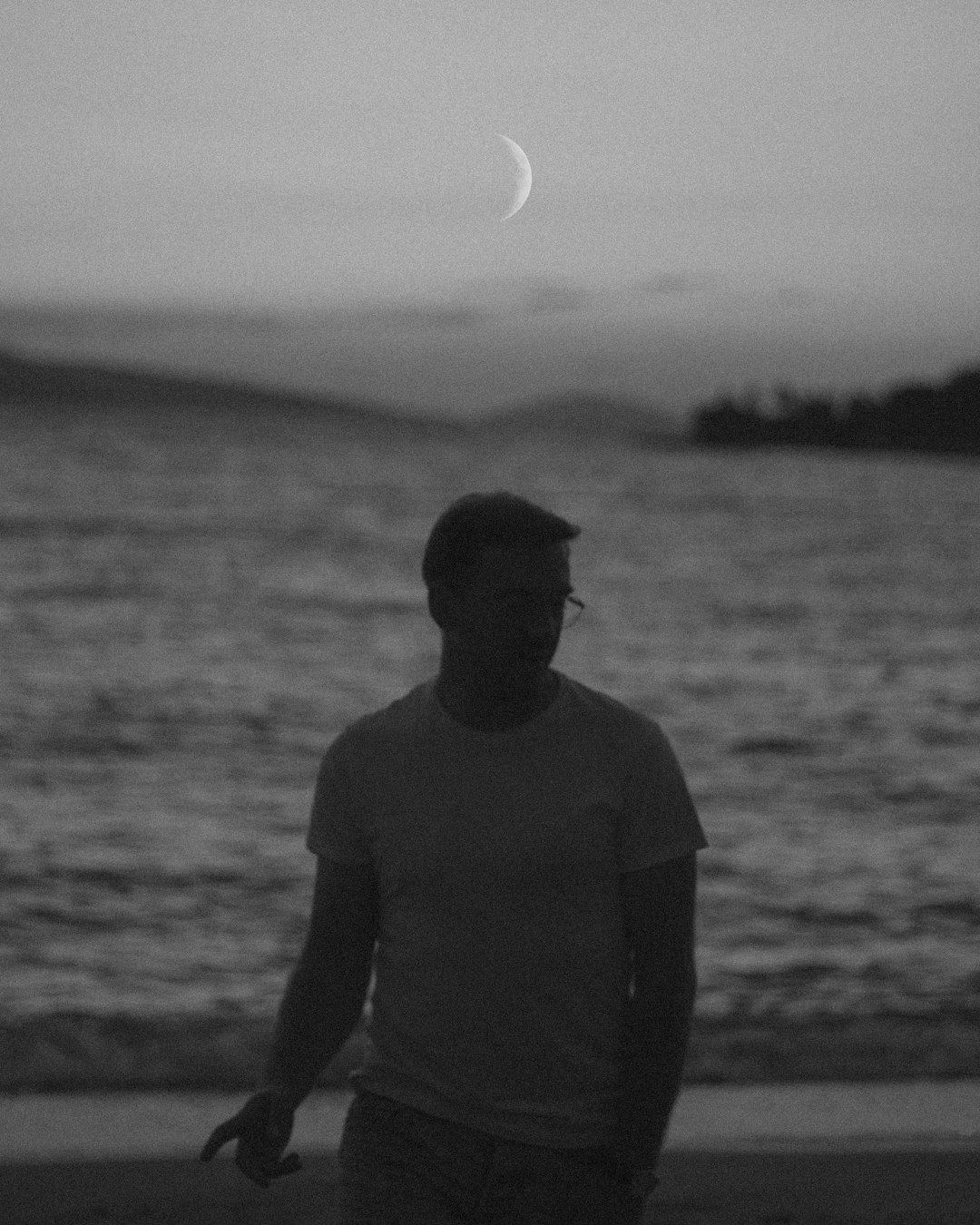 man in black hat standing on seashore during daytime