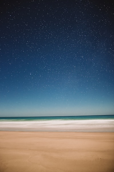 A serene scene of a person peacefully reading their yearly horoscope under a starlit sky.