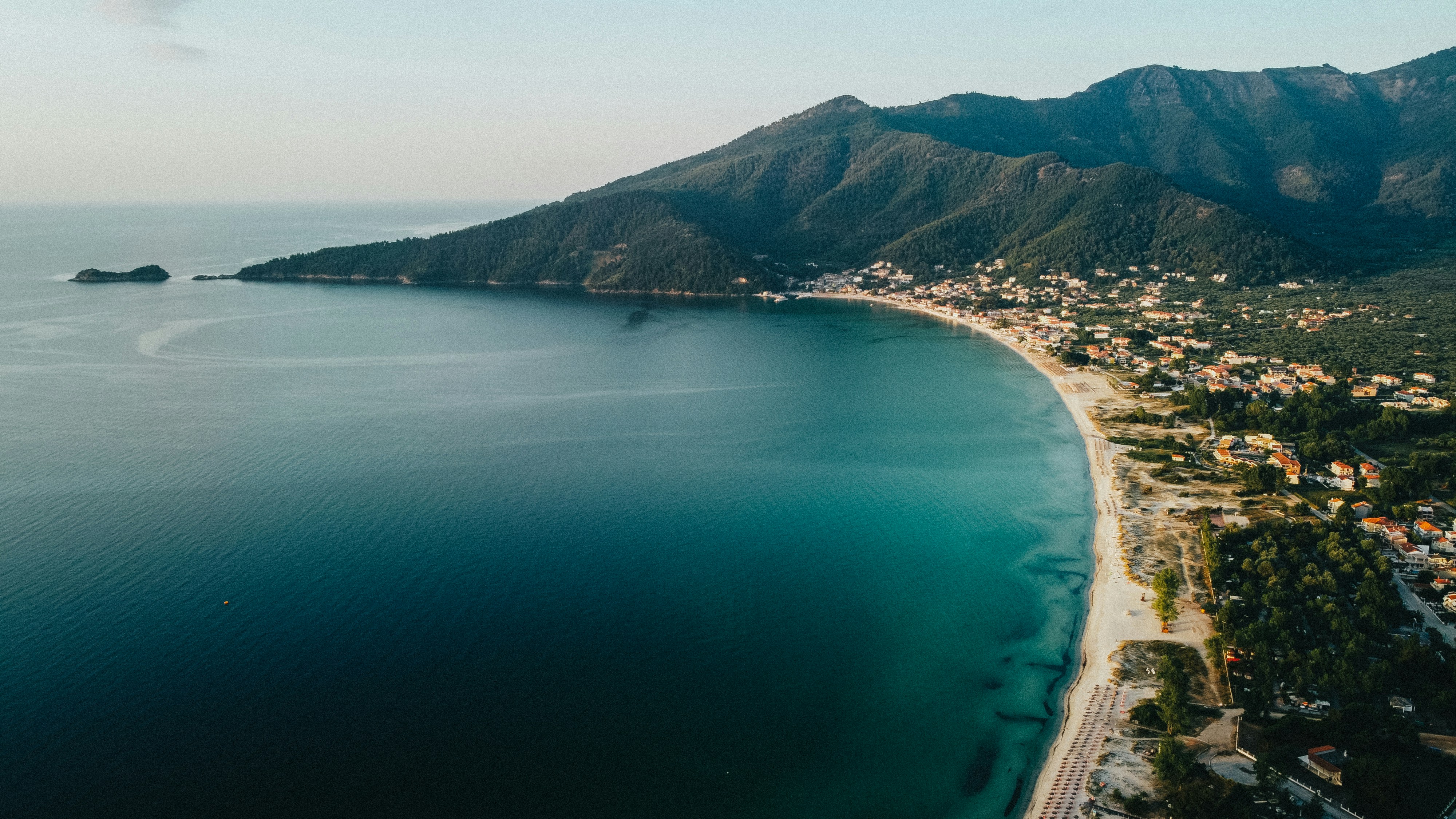 aerial view of green mountain beside body of water during daytime