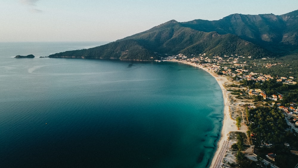 aerial view of green mountain beside body of water during daytime