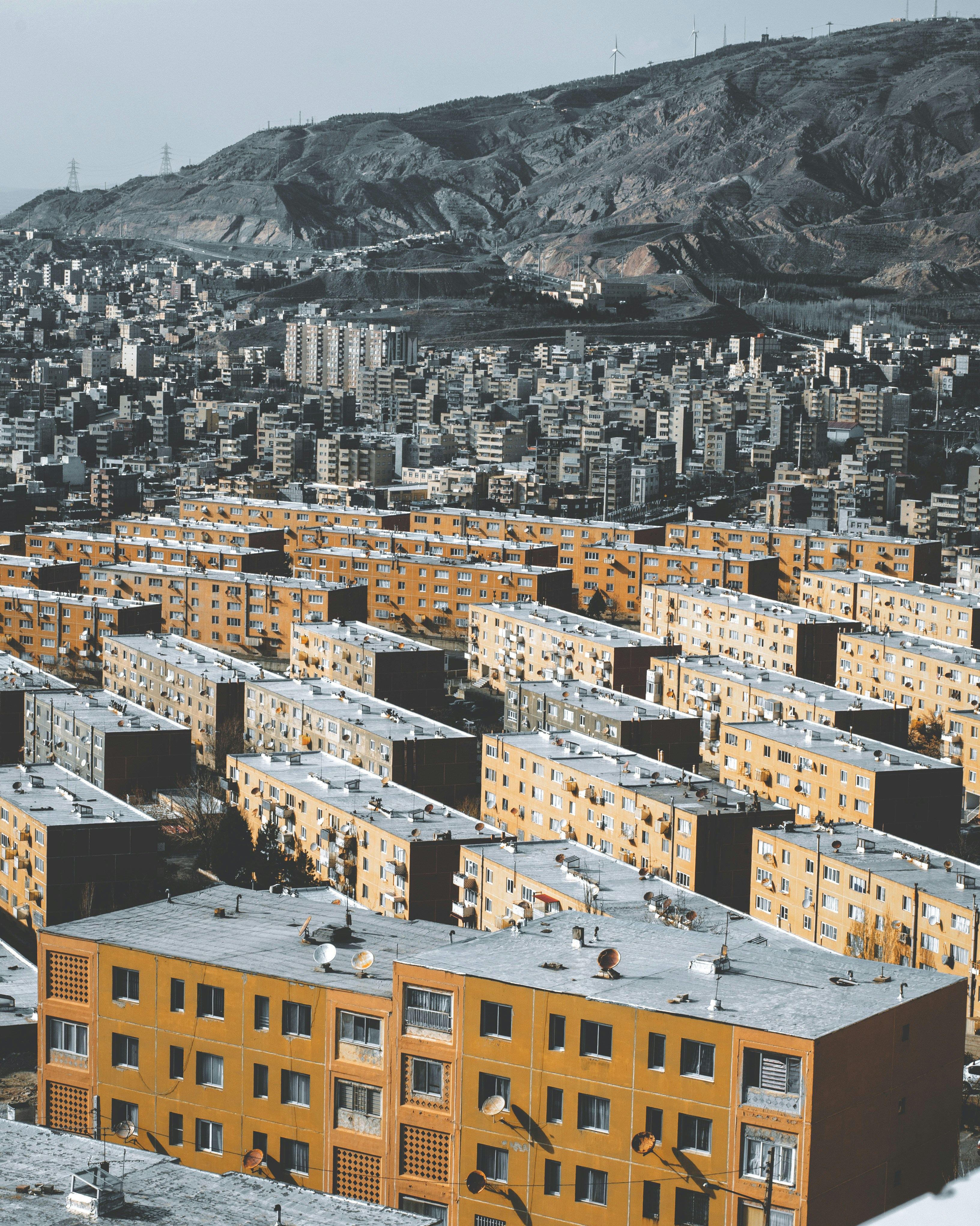 yellow and white concrete building near mountain during daytime
