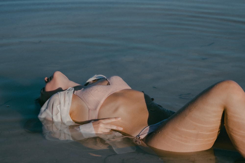 woman in white bikini lying on water