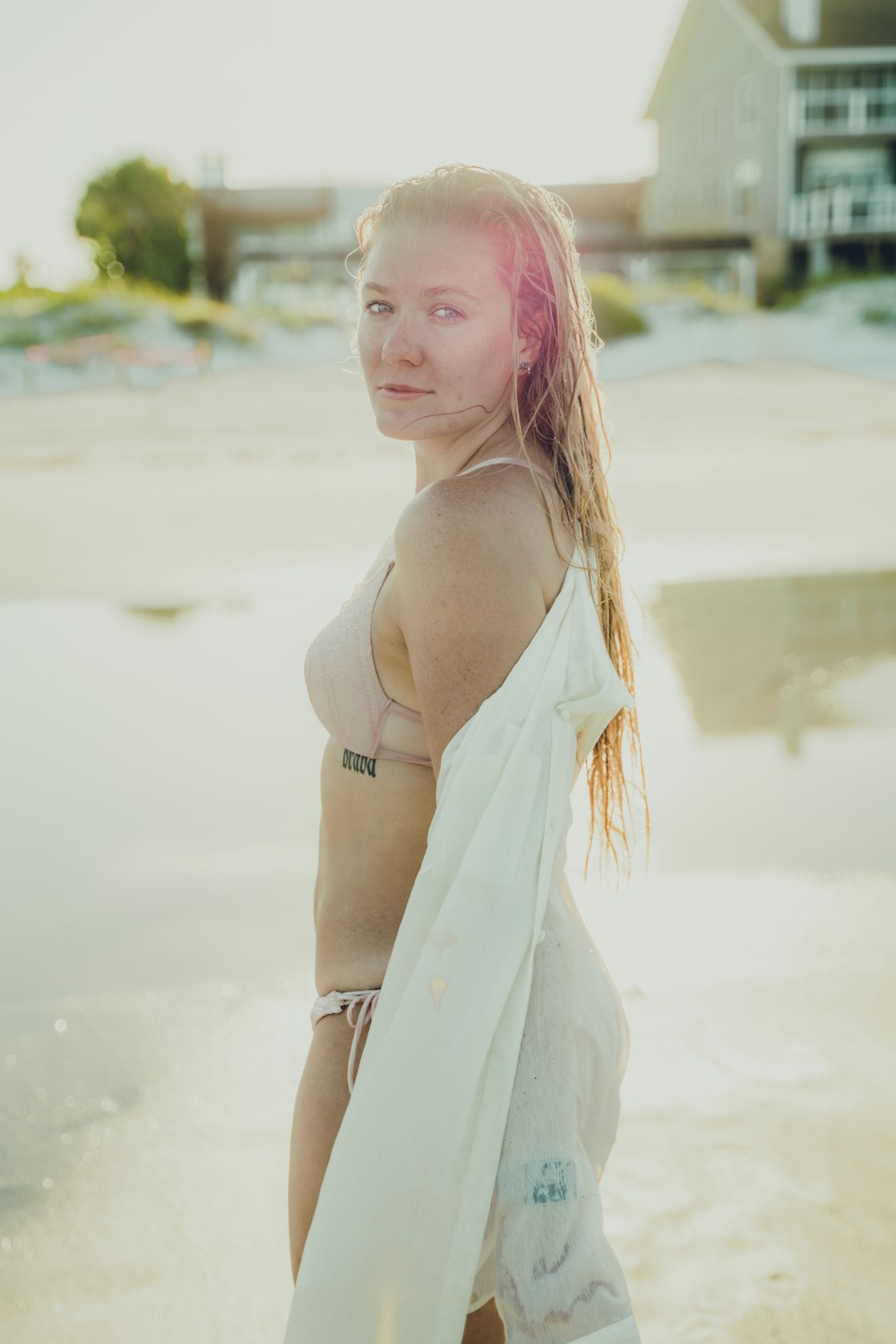 woman in white spaghetti strap top standing on beach during daytime