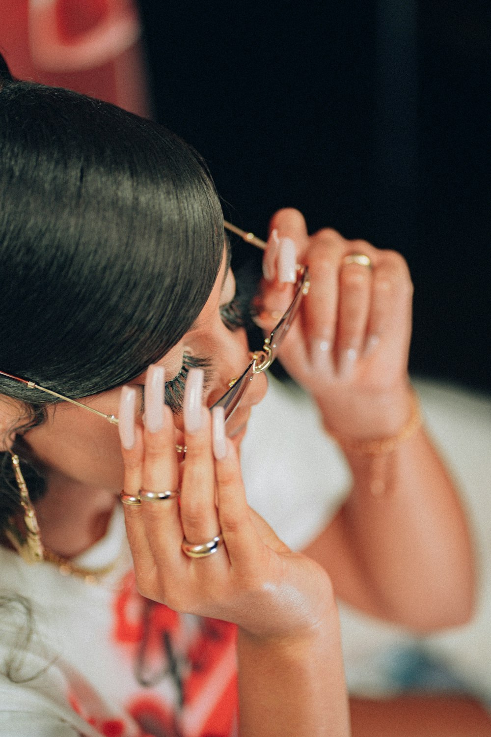 woman in white tank top wearing gold framed eyeglasses