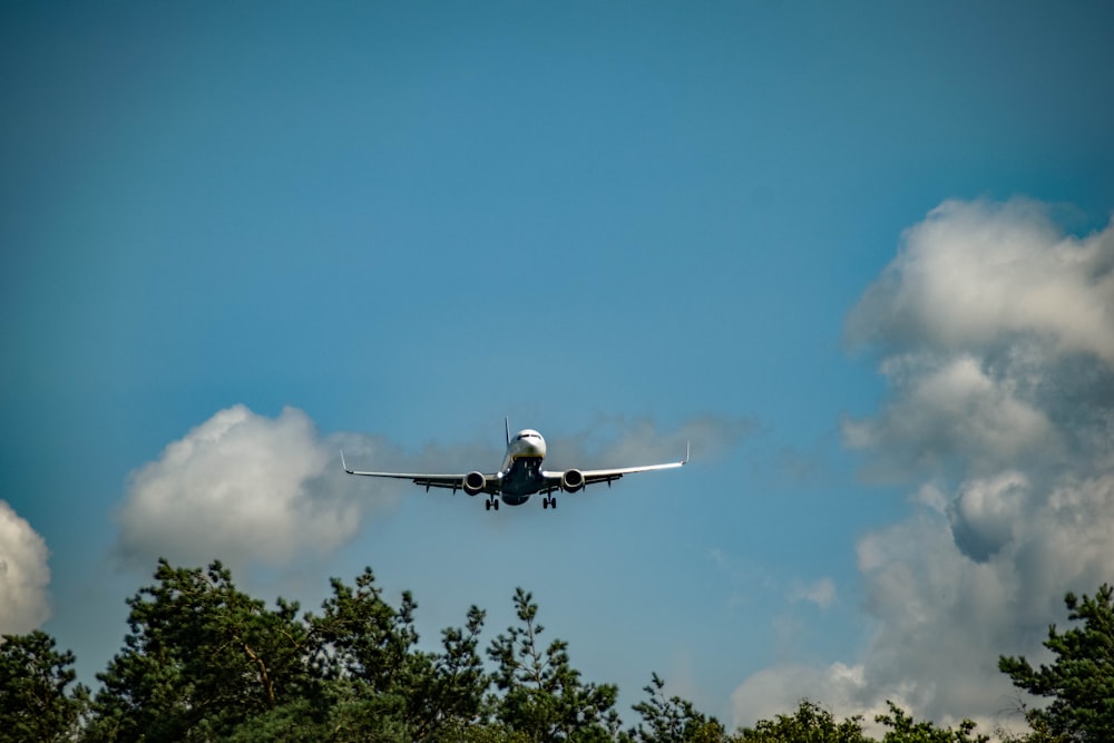 white airplane flying in the sky during daytime