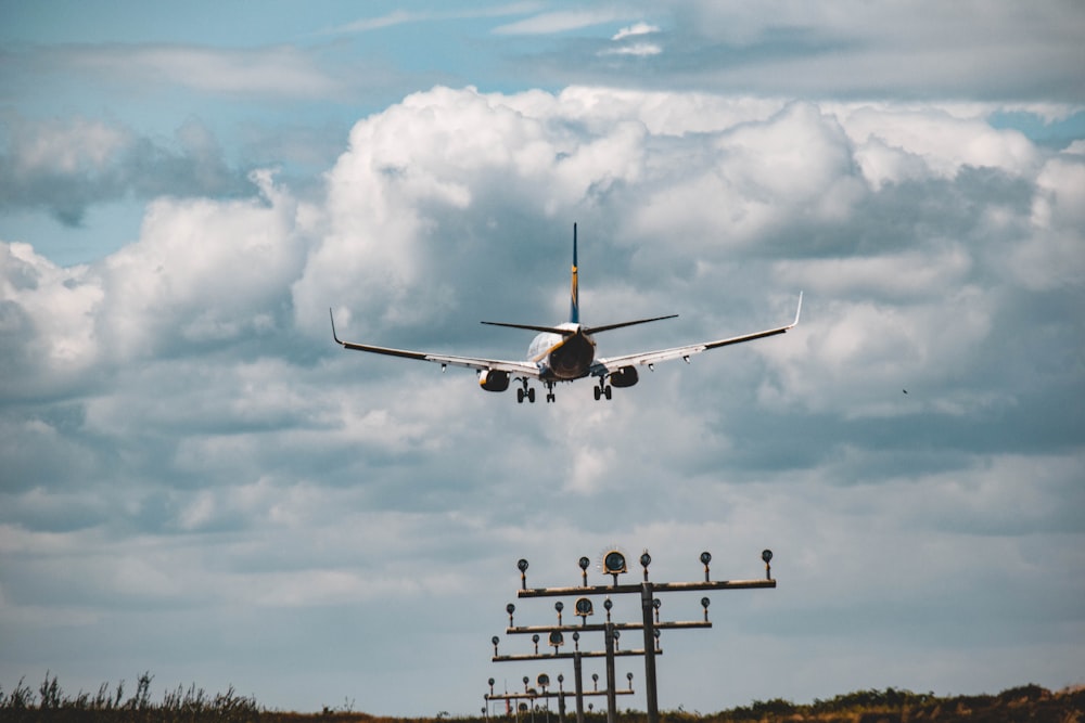 Avión blanco y azul volando sobre las nubes durante el día