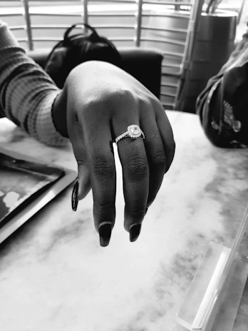 A close-up of a sparkling ring resting on a marble table.