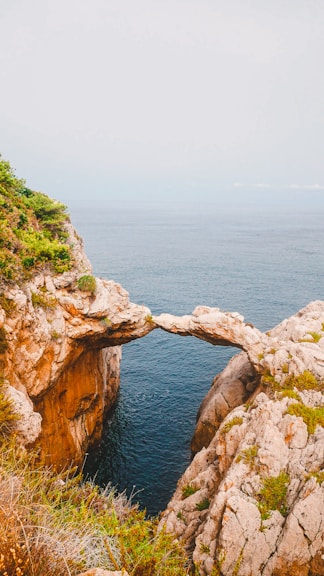brown rock formation near blue sea during daytime