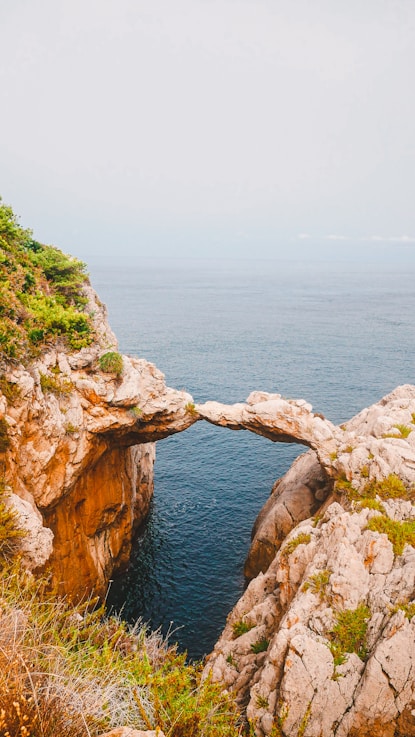 brown rock formation near blue sea during daytime