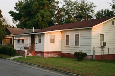 white and brown wooden house near green trees during daytime