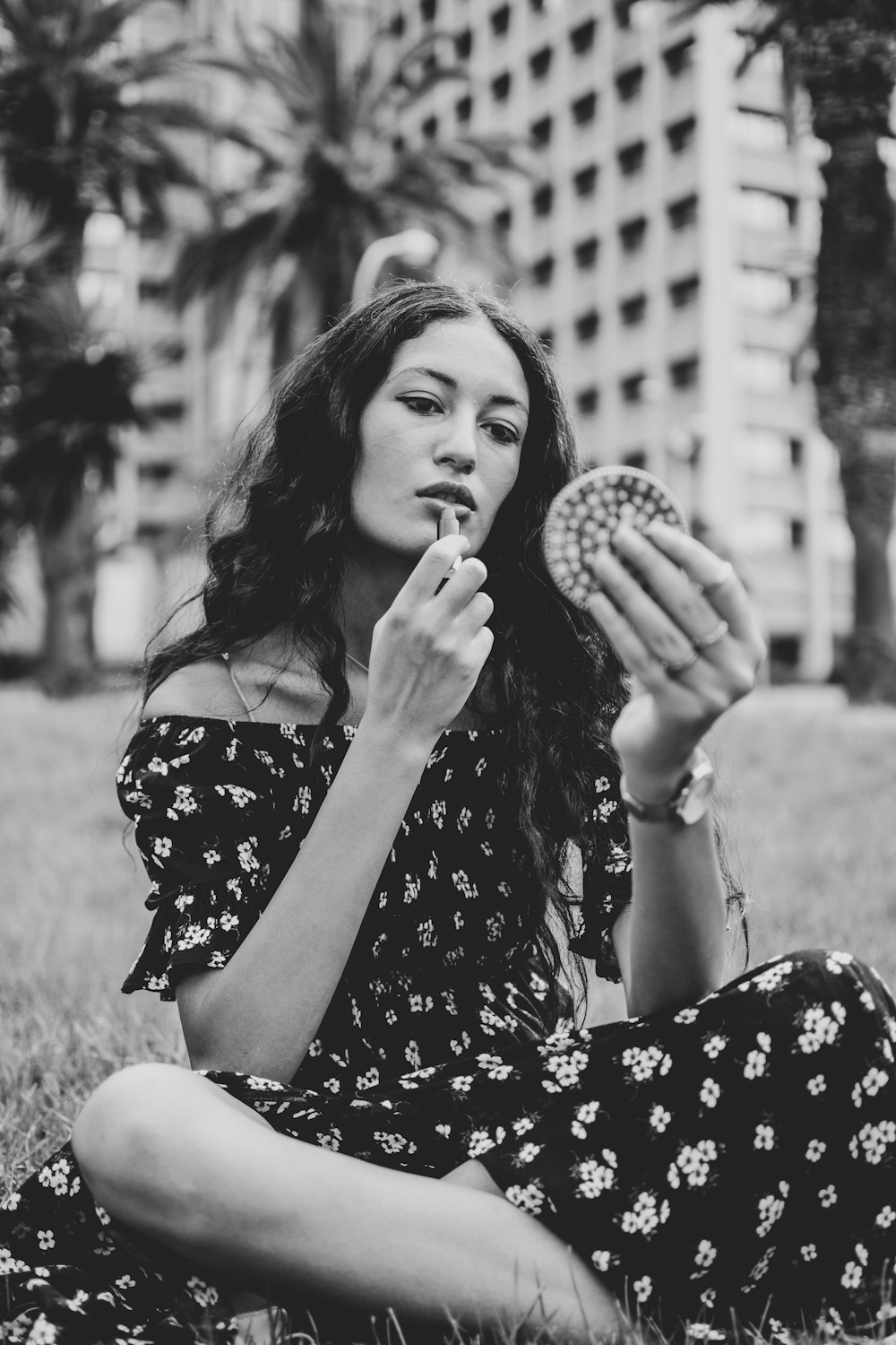 grayscale photo of woman in floral dress holding round fruit