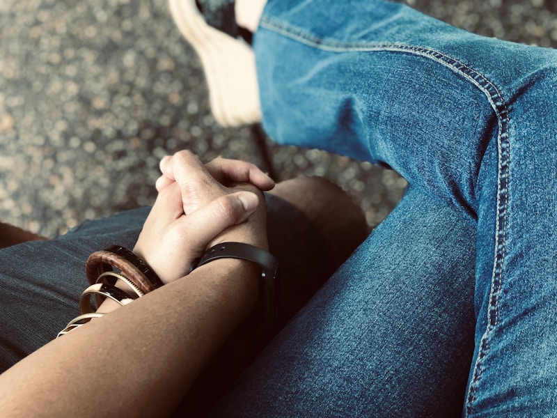 person in blue denim jeans sitting on black chair