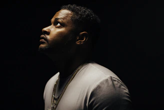 Studio shot of a thoughtful individual with soft lighting emphasizing emotion.