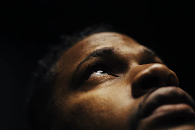 Close-up of a person’s eyes reflecting a dimly lit recording studio, capturing intensity and focus.