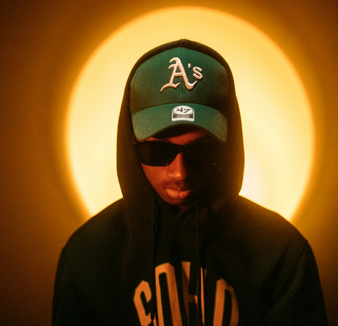 man in black and white hoodie wearing black and white fitted cap