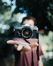 black and silver camera on persons hand