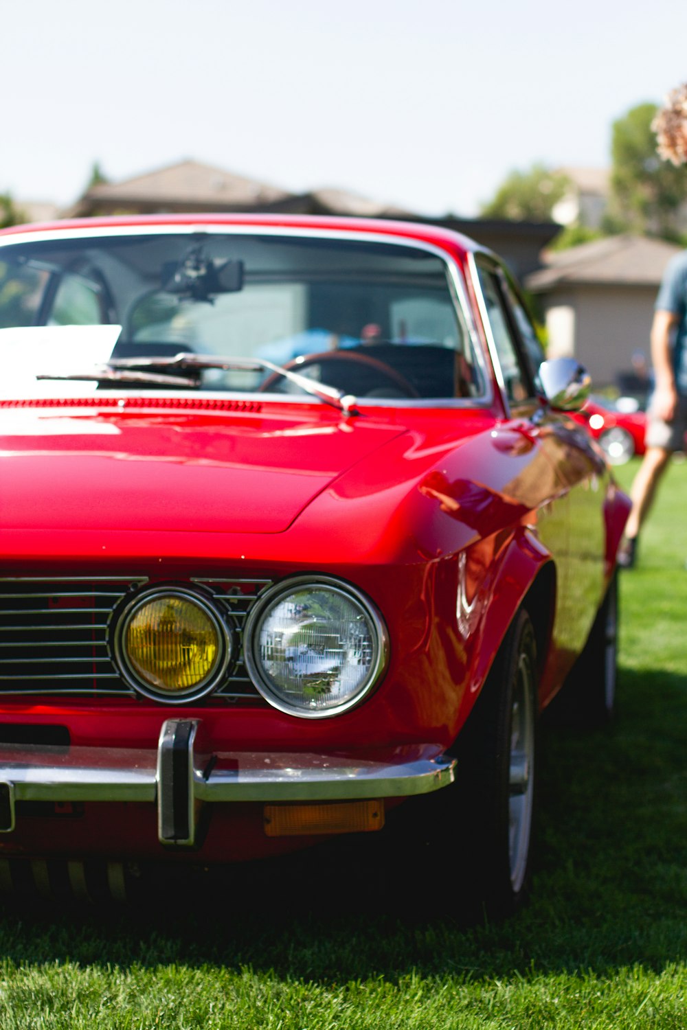 red car on green grass field during daytime