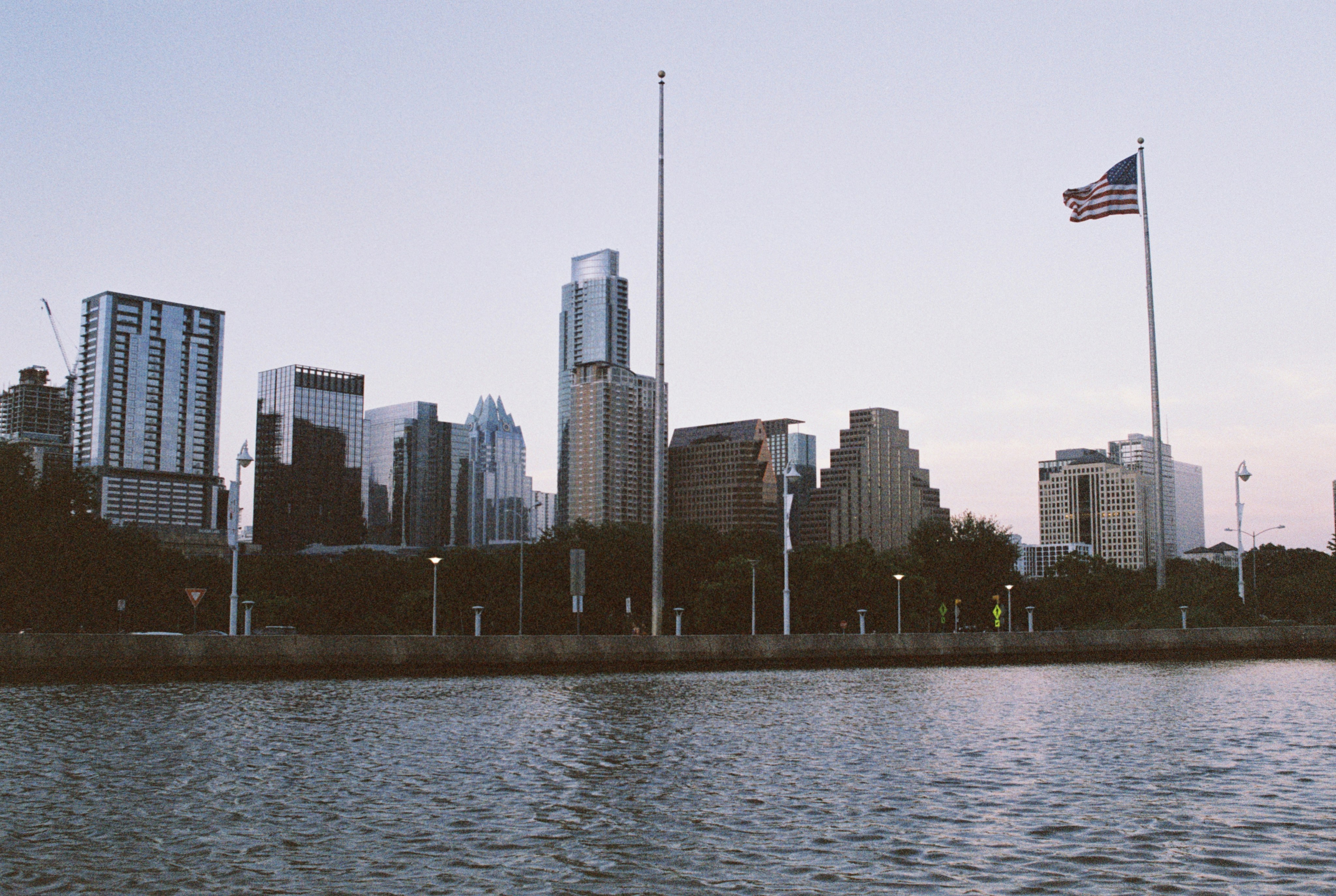 us a flag on pole near body of water during daytime