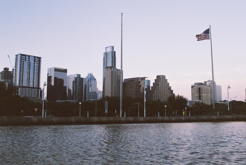 us a flag on pole near body of water during daytime