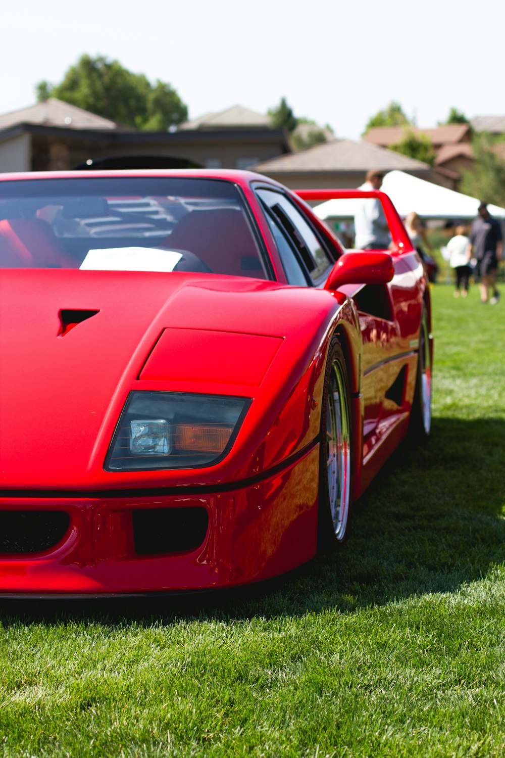 red ferrari 458 italia on green grass field during daytime