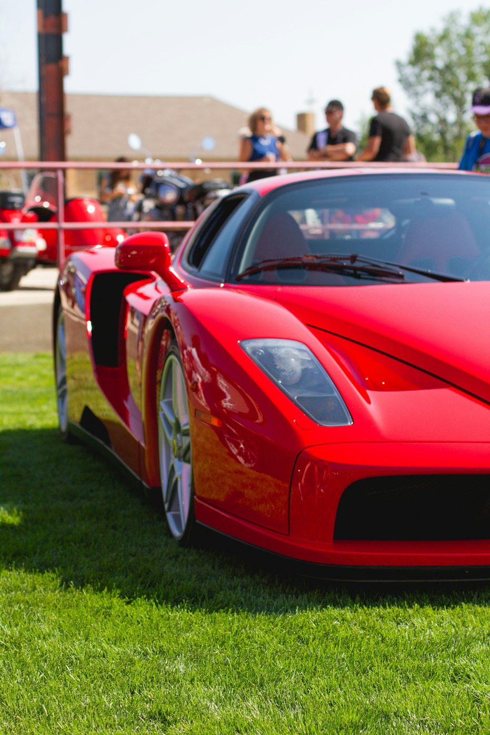 Ferrari 458 Italia rouge sur un terrain d’herbe verte pendant la journée