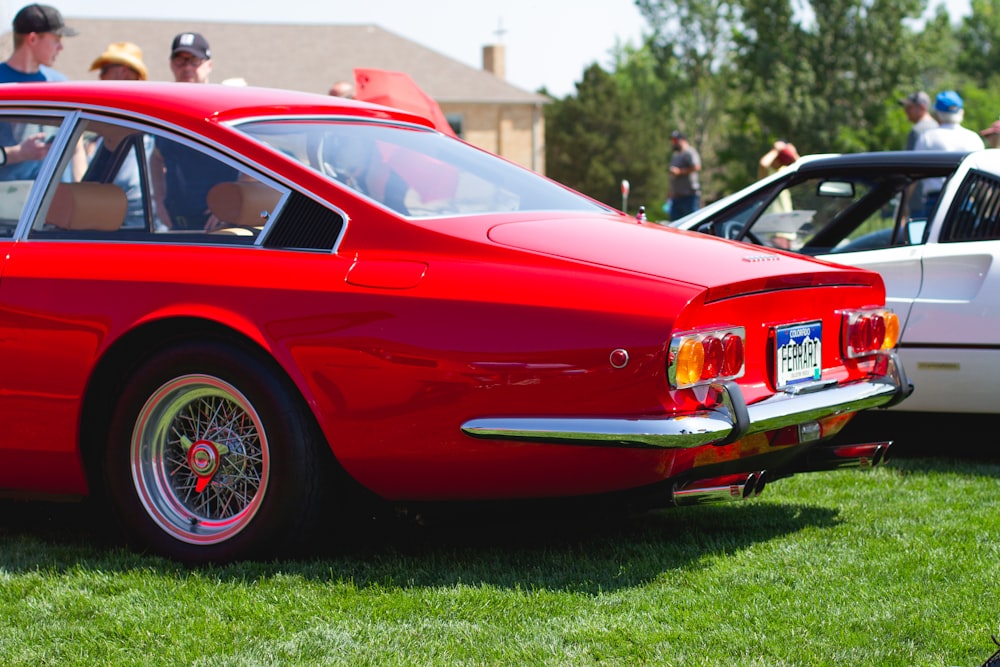 red porsche 911 parked on green grass field during daytime