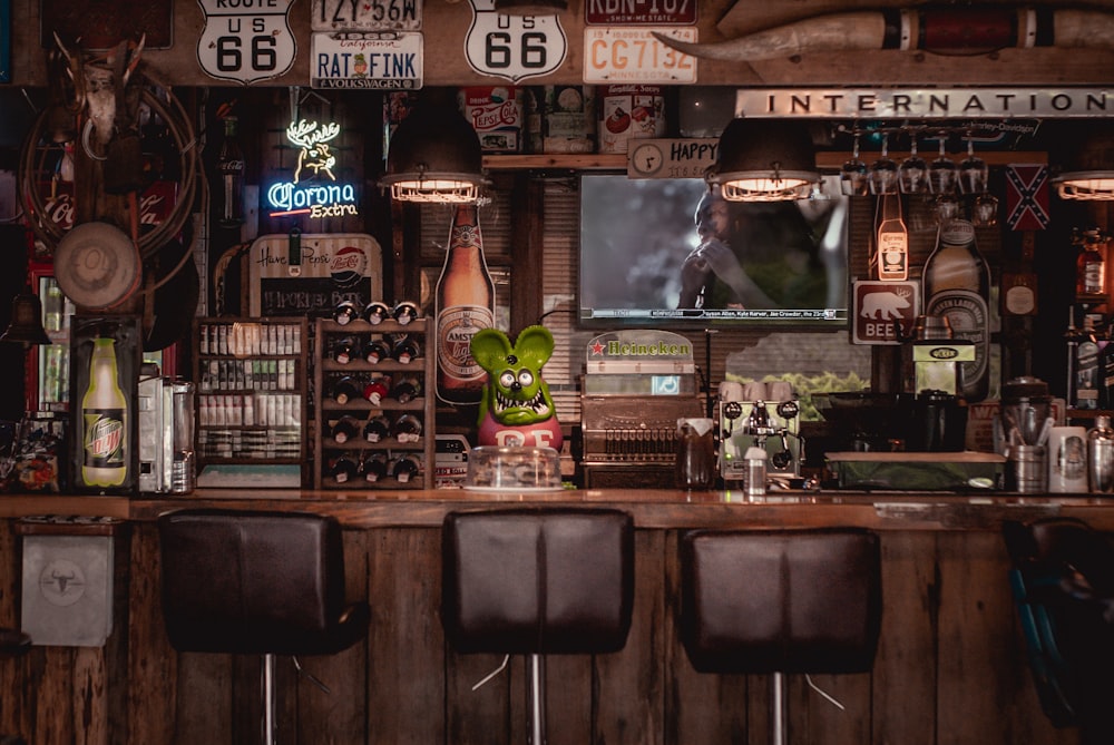 Tabourets de bar en cuir noir à côté d’un comptoir de bar en bois brun