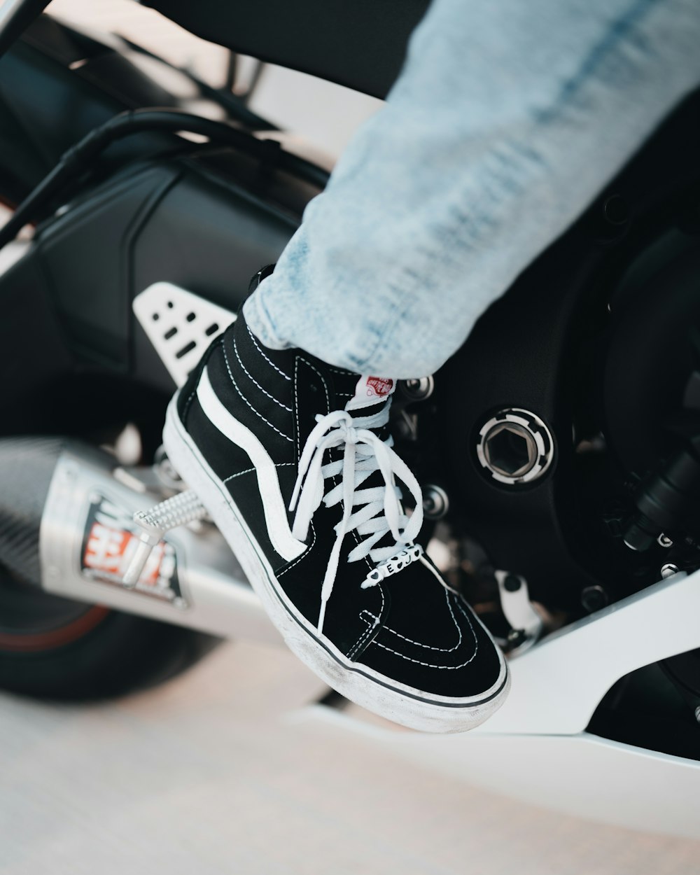 person in blue denim jeans and black and white nike sneakers