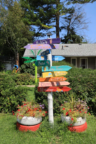 Close-up of a colorful signpost surrounded by blooming spring flowers in bright pastel shades.