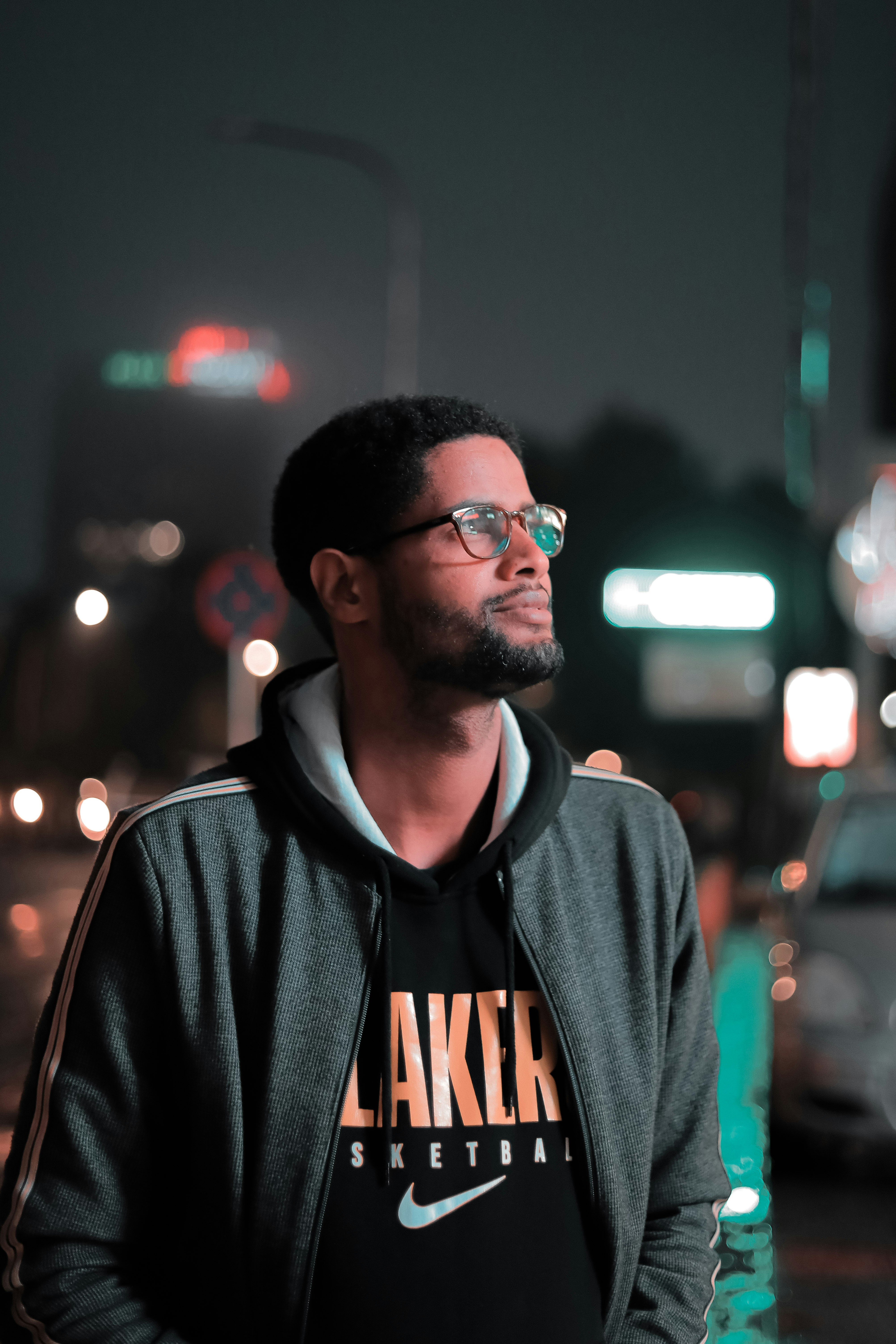 Mann in schwarz-orangefarbenem Kapuzenpulli mit Brille