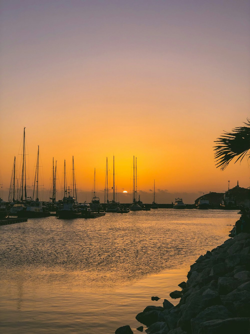 silhouette of boats on sea during sunset