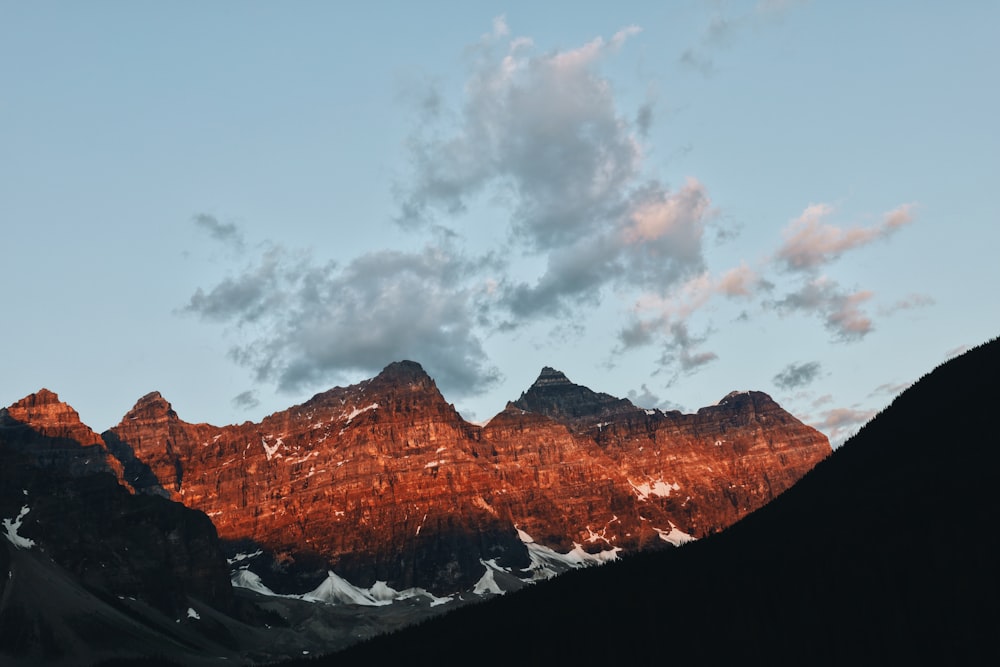 brown rocky mountain under white clouds during daytime