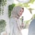 woman in white and blue floral hijab holding microphone