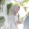 woman in white and blue floral hijab holding microphone