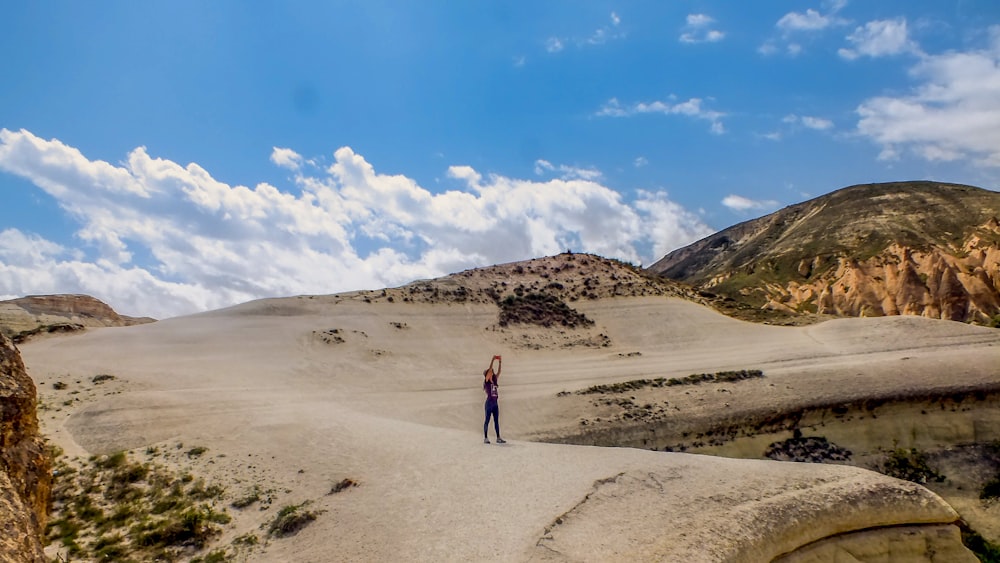 person in black jacket walking on white sand during daytime