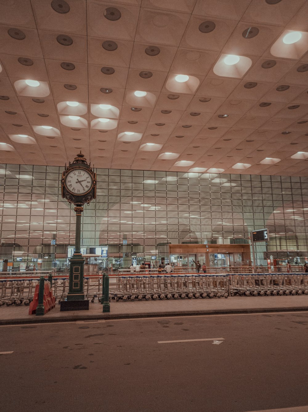 people walking inside building with analog wall clock