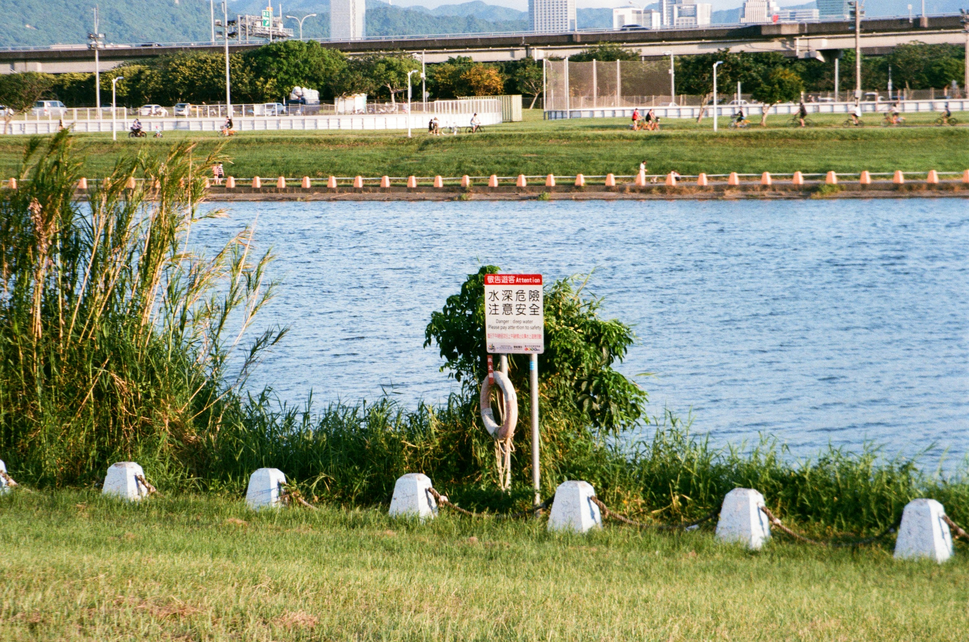 red and white metal signage near body of water during daytime